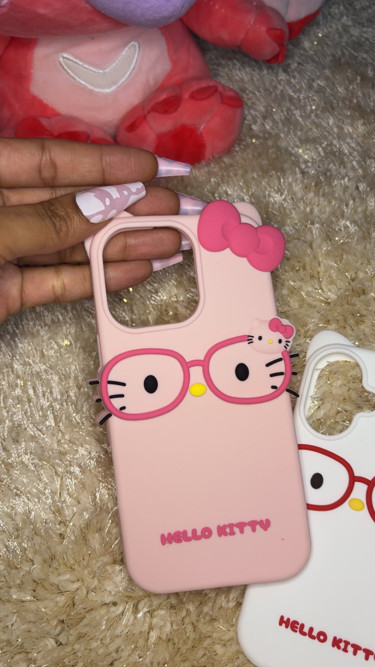 Hello Kitty iPhone case with Hello Kitty face wearing glasses, available in white and pink options.